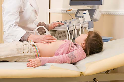 Foto de un niño que se somete a un examen de ultrasonido abdominal