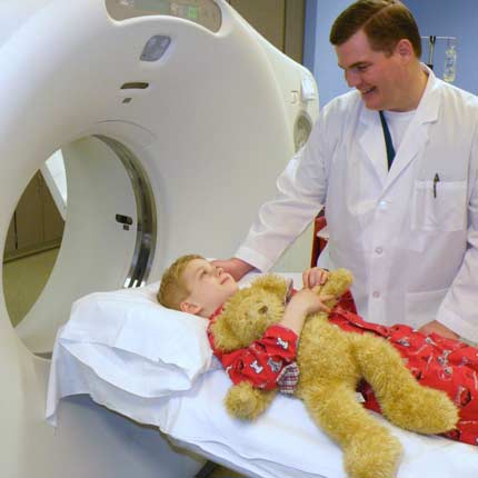 Photo of a technologist preparing a child for a CT scan.