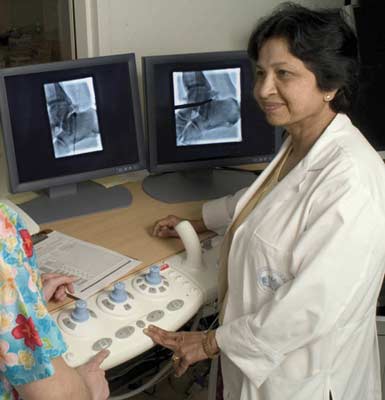 Radiólogo del sistema musculoesquelético utilizando imágenes fluoroscópicas para programar una artrografía de tobillo.