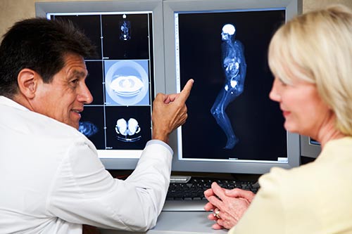 A photo of a radiologist and a patient reviewing MRI images