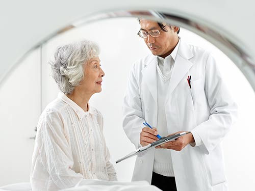 Radiologist preparing patient for magnetic resonance imaging (MRI) exam.