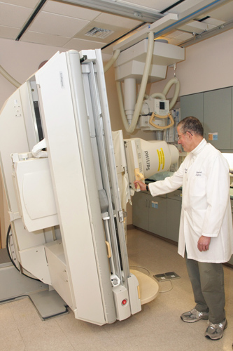 Imagen de una mesa de fluoroscopia ubicada en posición vertical