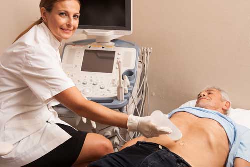 Radiólogo preparando a un paciente para un examen de ultrasonido abdominal.