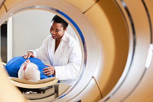 Photograph of a radiologist preparing a patient for a computed tomography (CT) exam.