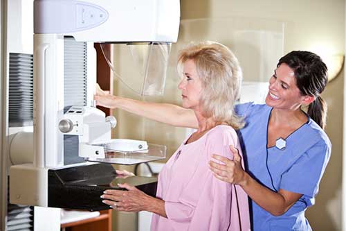 Photo of a patient and technologist during a mammography procedure.