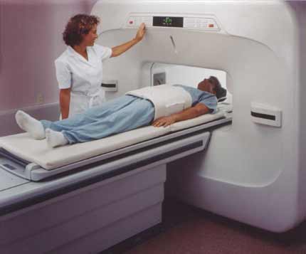 Technologist with patient undergoing open MRI