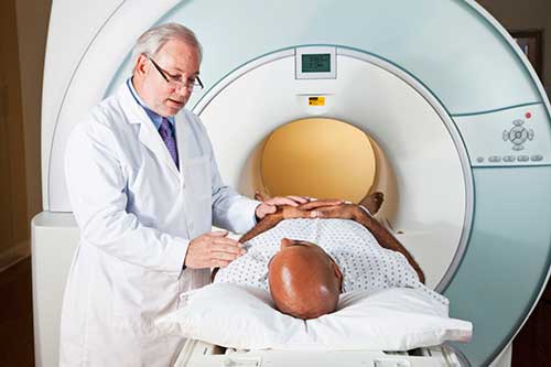 Fotografía de un radiólogo que prepara a un paciente para un examen de resonancia magnética (MRI).