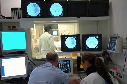 Photo of an interventional radiologist performing an angiography exam.