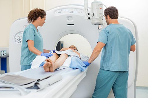 Foto de un radiólogo que prepara a un paciente para un examen de tomografía computarizada (TC).
