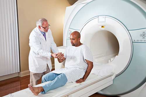 Foto de un radiólogo que prepara a un paciente para un examen de resonancia magnética (MRI).