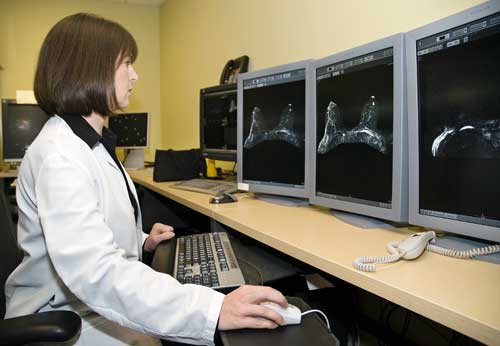 Radióloga visualiza exploraciones de resonancia magnética de mama