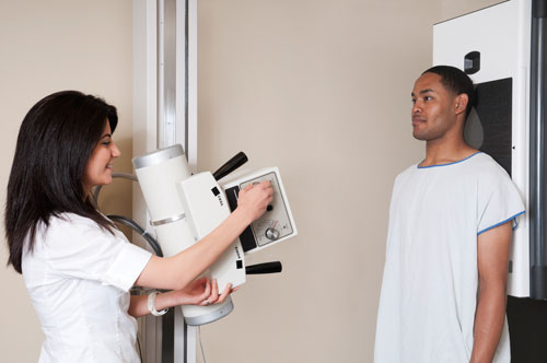 Photo of technologist and patient during a chest x-ray procedure. 