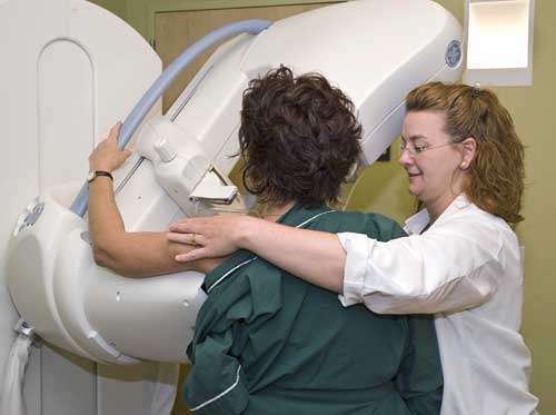 Photo of a technologist assisting a patient during a mammogram.