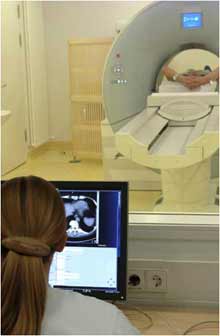 Technologist monitors patient undergoing CT scan.